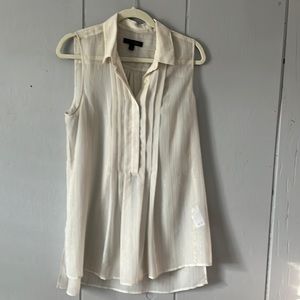 Large sleeveless top with gold stitching. Worn over camisole.